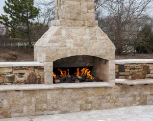 engineered stone outdoor fireplace on paver patio